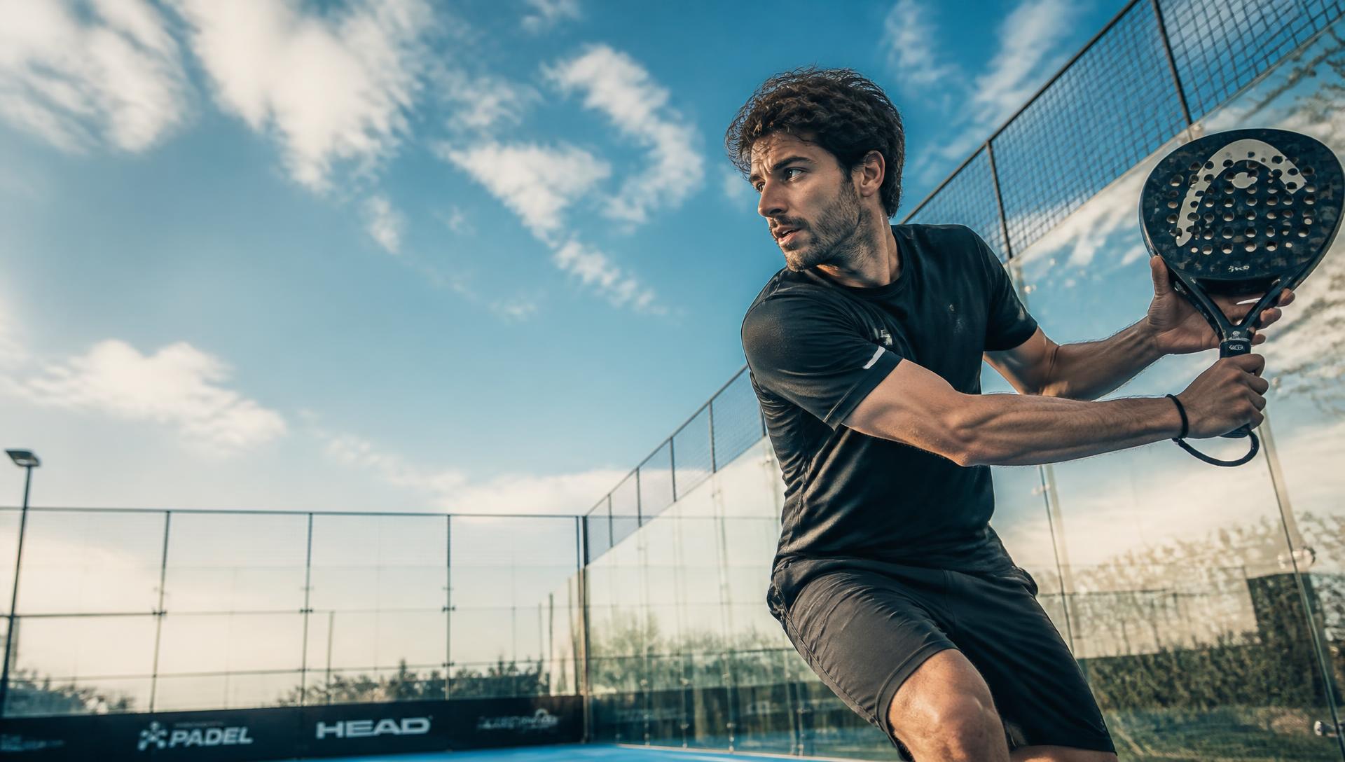 Jugador de pádel golpeando la pelota en la cancha de Quevedo Padel Club